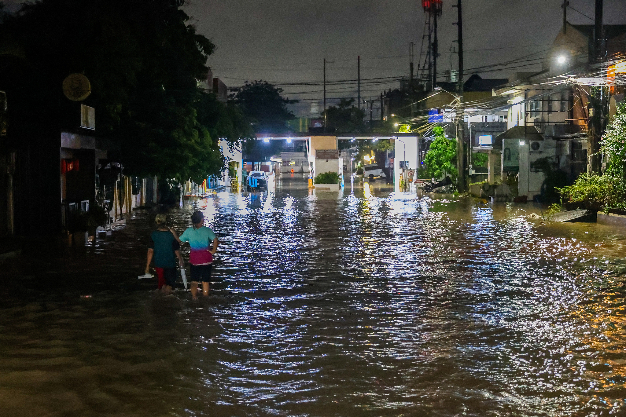 Residents wade through a flooded residential area in Cainta, Rizal, Philippines, August 18, 2026. /VCG