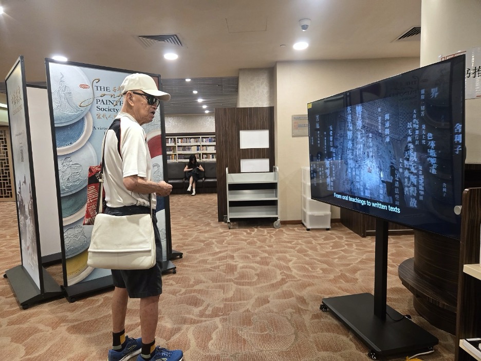 Mr. Long watches one of the films featured in China Crafted at Chinatown Library. /CGTN