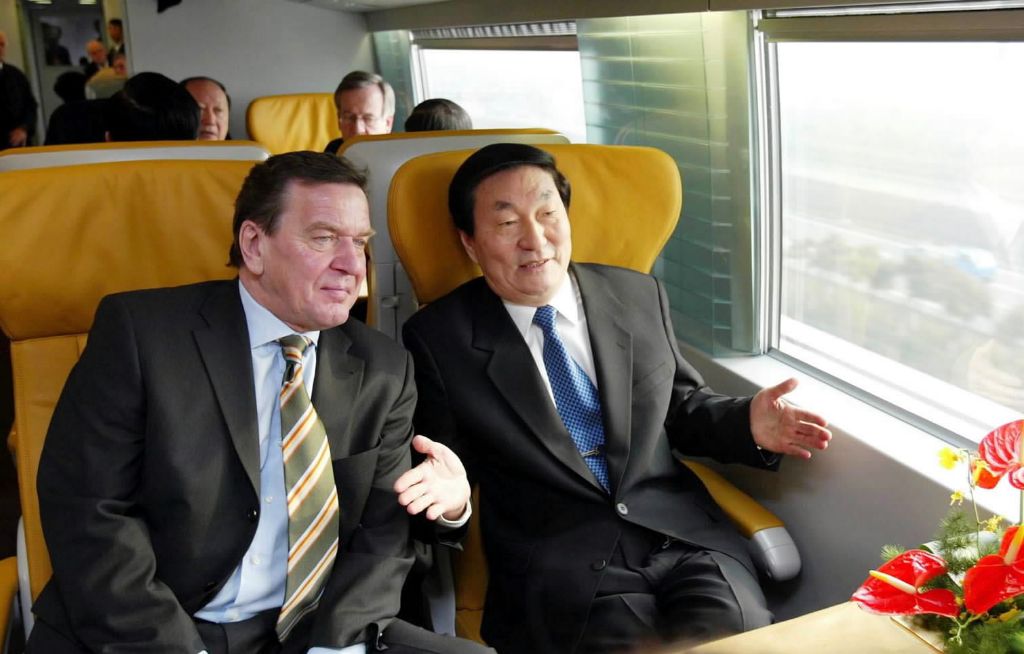 Zhu Rongji (R) and German Chancellor Gerhard Schroder take the maglev train in Shanghai, December 31, 2002. /Xinhua