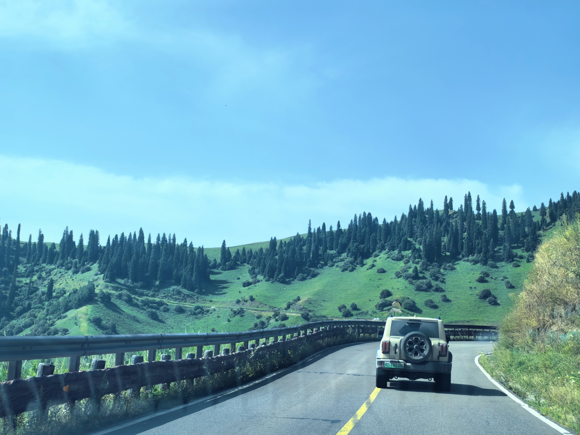 A car drives along the highway across the Narat Grassland in northwest China's Xinjiang Uygur Autonomous Region, on July 24, 2026. /CGTN