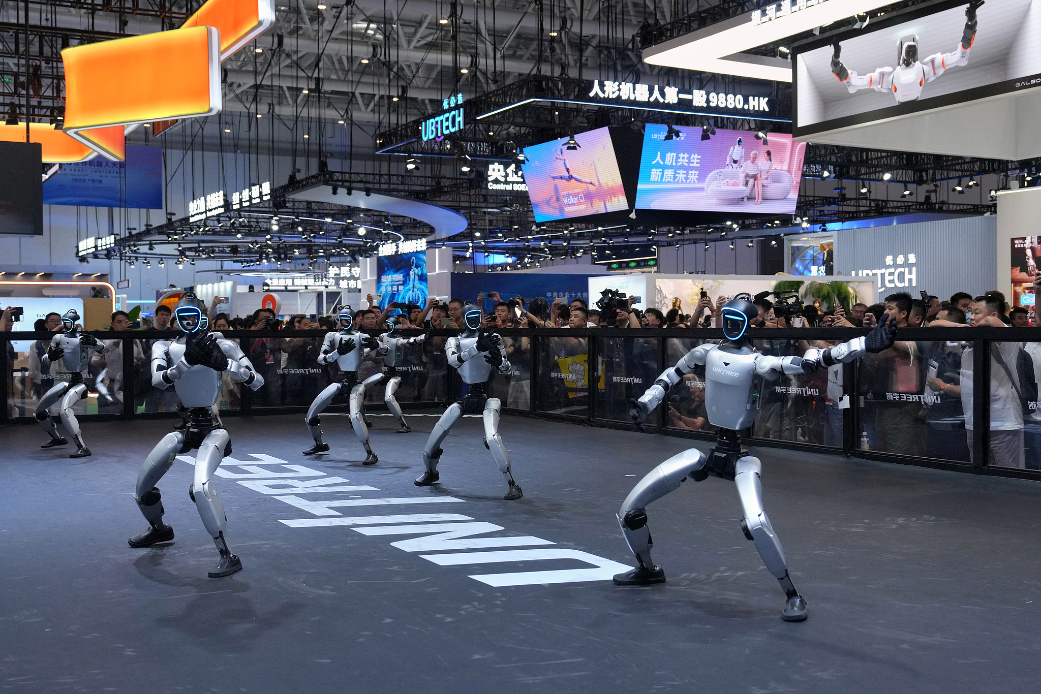 Visitors watch a performance by humanoid robots during the World Robot Conference at the Beijing Yichuang International Convention and Exhibition Centre in Beijing, August 19, 2026. /VCG 