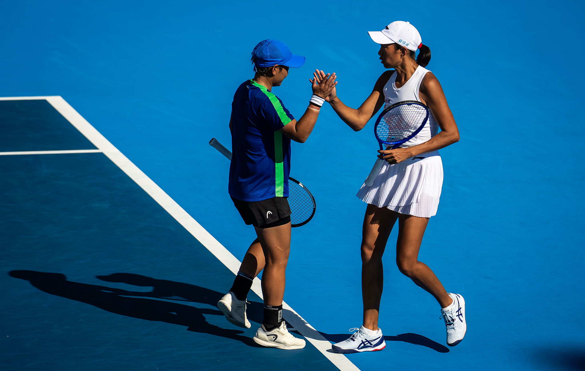 China's Zhang Shuai (R) and Jiang Xinyu high-five each other in the women's doubles quarterfinal match against American duo Iva Jovic and Caty McNally at the Cincinnati Open in Cincinnati, Ohio, August 20, 2026. /VCG