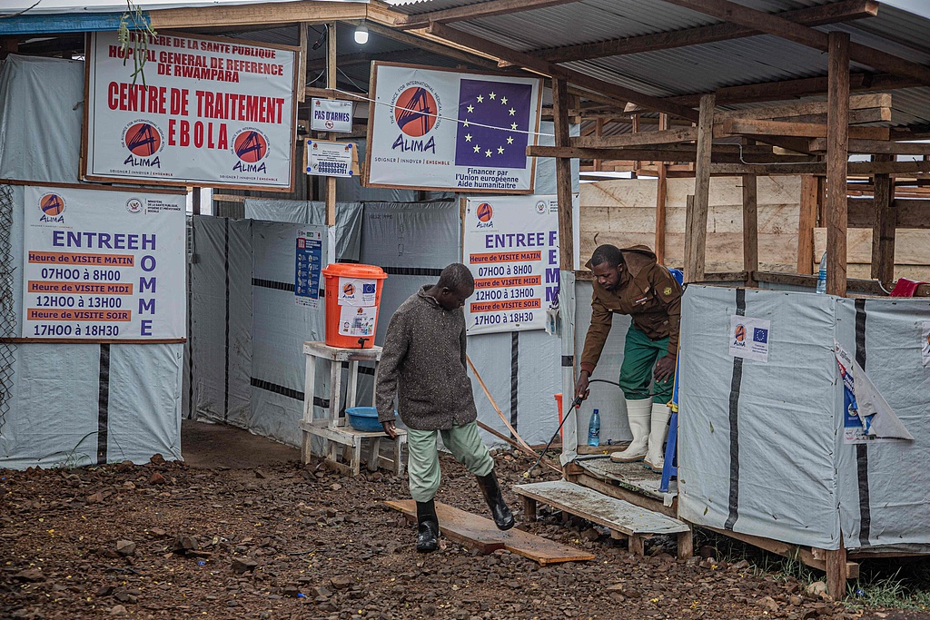 A hygiene worker disinfects a person's feet at the entrance to the Rwampara Ebola treatment center in Bunia, Ituri Province, Eastern DRC, July 13, 2026. /VCG