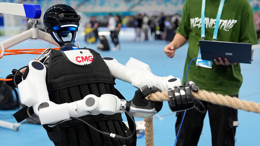 A humanoid robot is preparing for a tug of war competition during 2026 World Humanoid Robot Games at National Speed Skating Oval in Beijing, China, August 18, 2026. /VCG