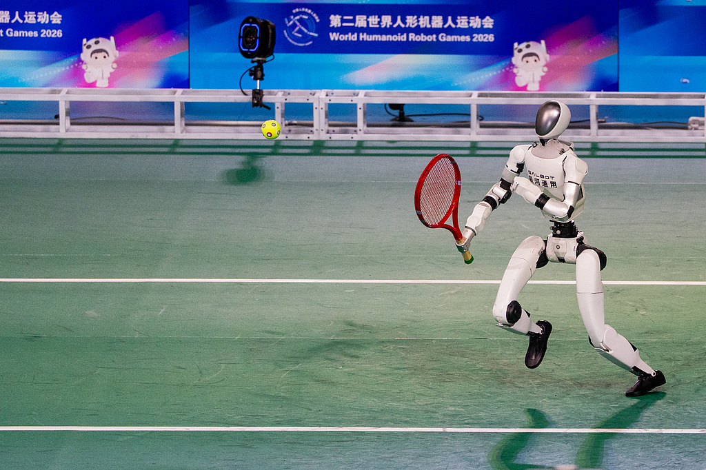 A humanoid robot plays tennis during the opening ceremony of the second World Humanoid Robot Games at the National Speed Skating Oval in Beijing, China, August 22, 2026. /VCG