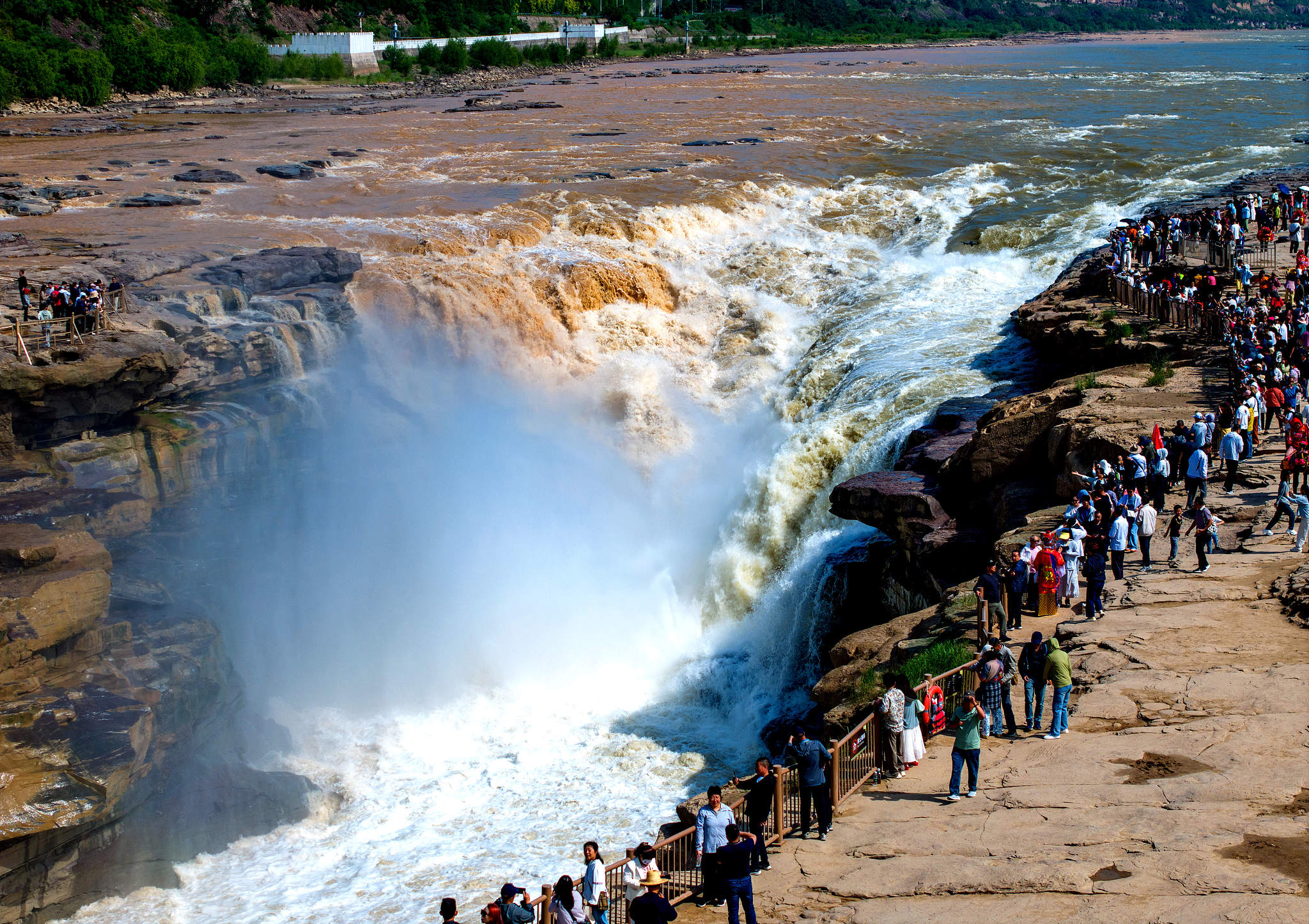 Tourists view the contrasting muddy and clear water at the Hukou Waterfall on the Yellow River, Jixian, north China's Shanxi Province, June 7, 2026. /VCG