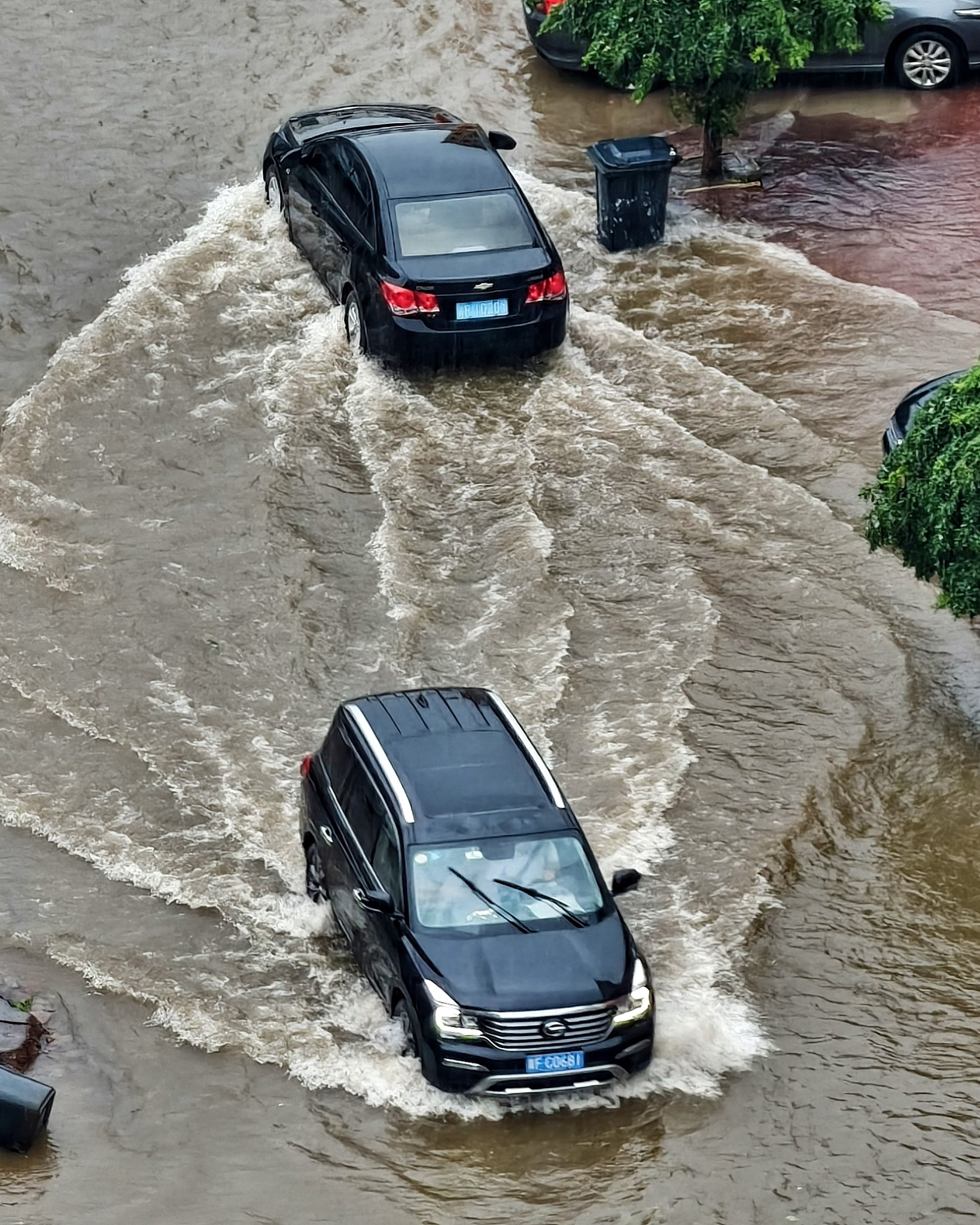 Vehicles navigate through a water-logged road section amid heavy rain, Baoding, north China's Hebei Province, July 25, 2026. /VCG