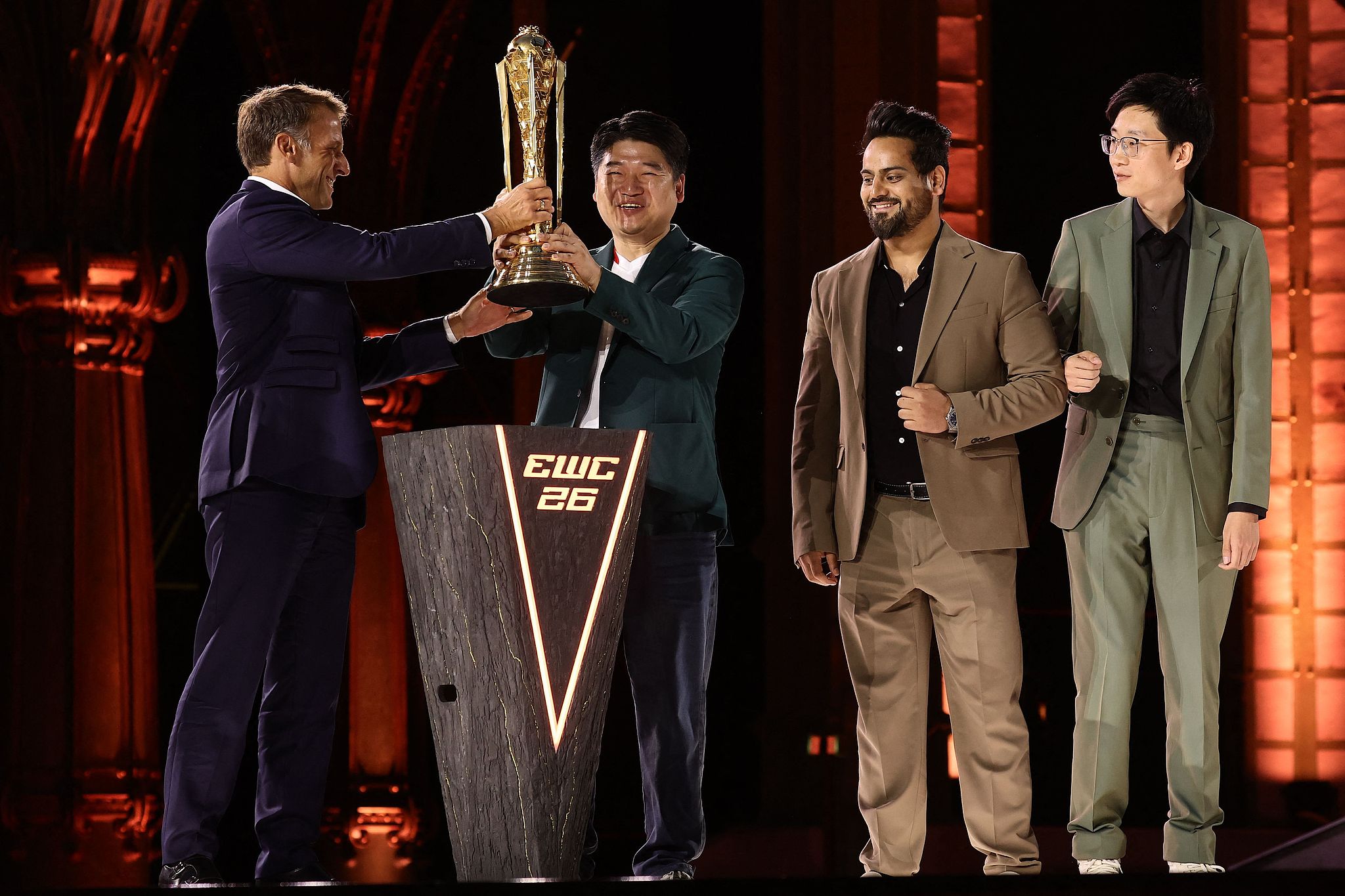 French President Emmanuel Macron (L) presents the EWC 2026 Club champions award to team All Gamers during the closing ceremony of the Esports World Cup at the Grand Palais in Paris, France, August 23, 2026. /VCG