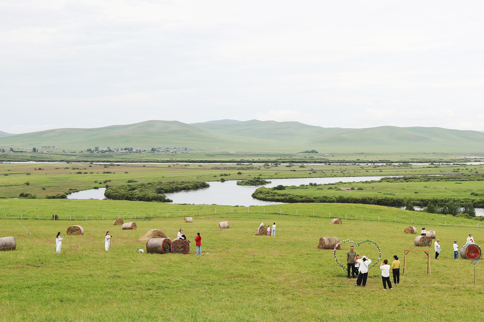 Visitors pose for photos on the Chinese side of the Ergun River in Hulunbuir, Inner Mongolia. /CGTN