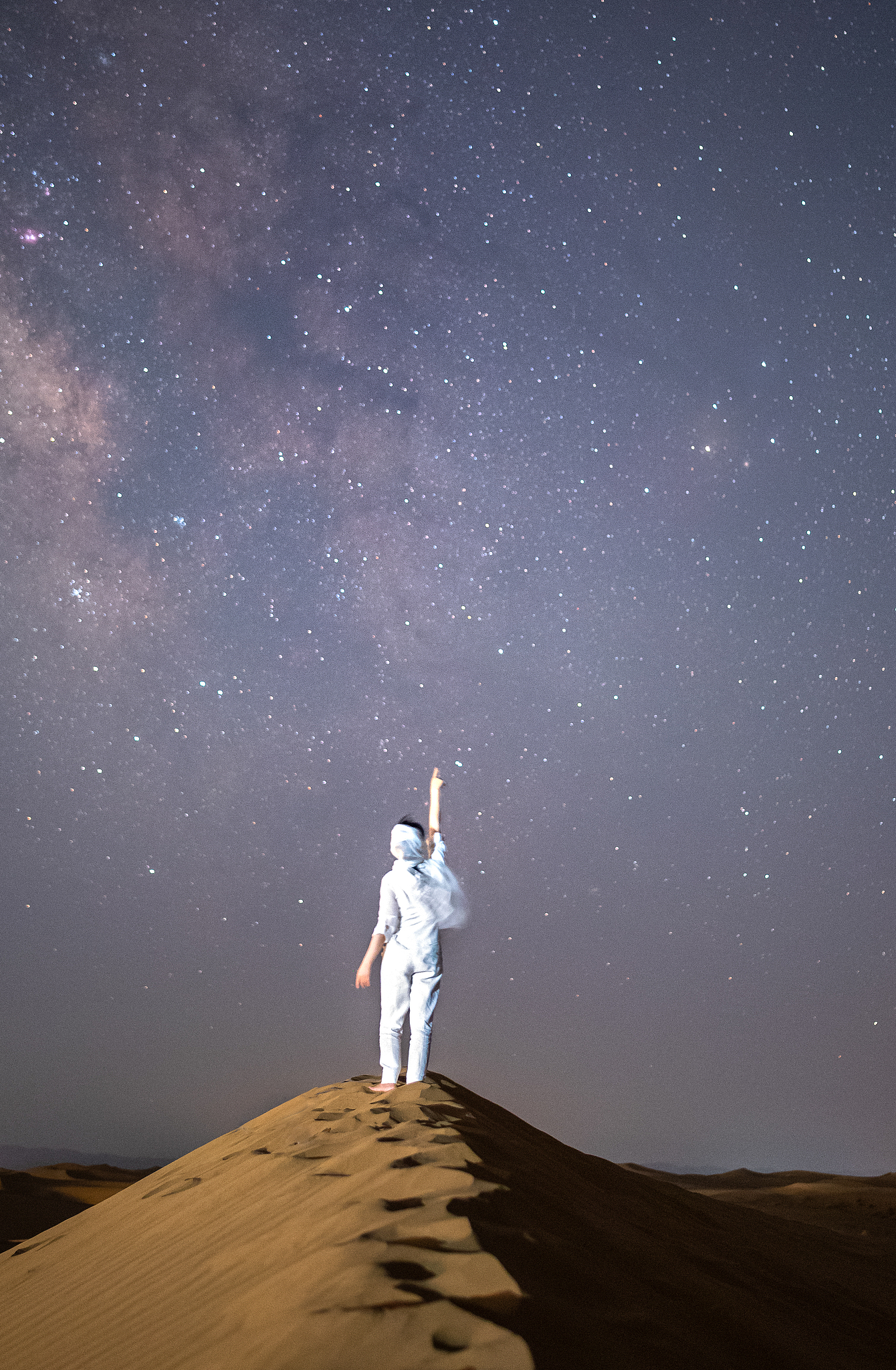 A file photo shows a visitor looking at the stars at the Shapotou Scenic Area in Zhongwei City, northwest China's Ningxia Hui Autonomous Region. /VCG