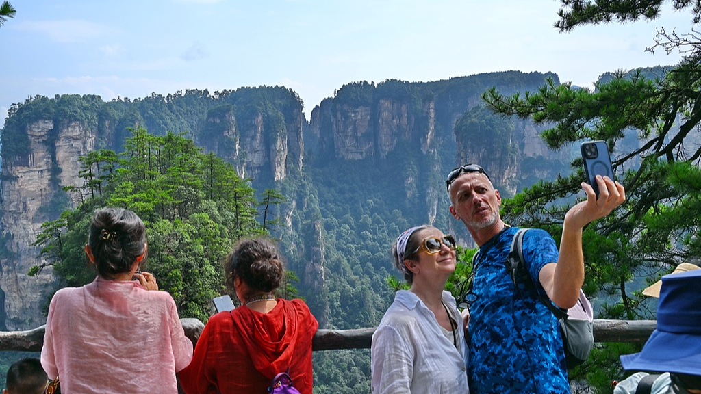 Foreign tourists enjoy the view and take photos at the Zhangjiajie National Forest Park, central China's Hunan Province, China, August 17, 2026.