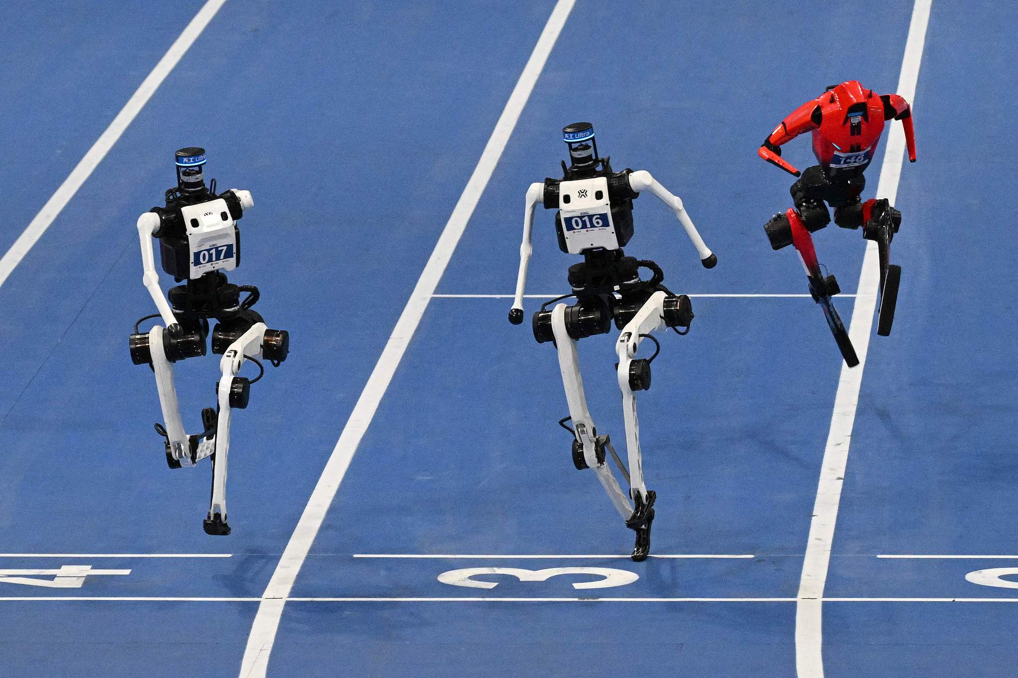 Humanoid robots compete in the large-size 100-meter final at the World Humanoid Robot Games in Beijing, August 26, 2026. /VCG