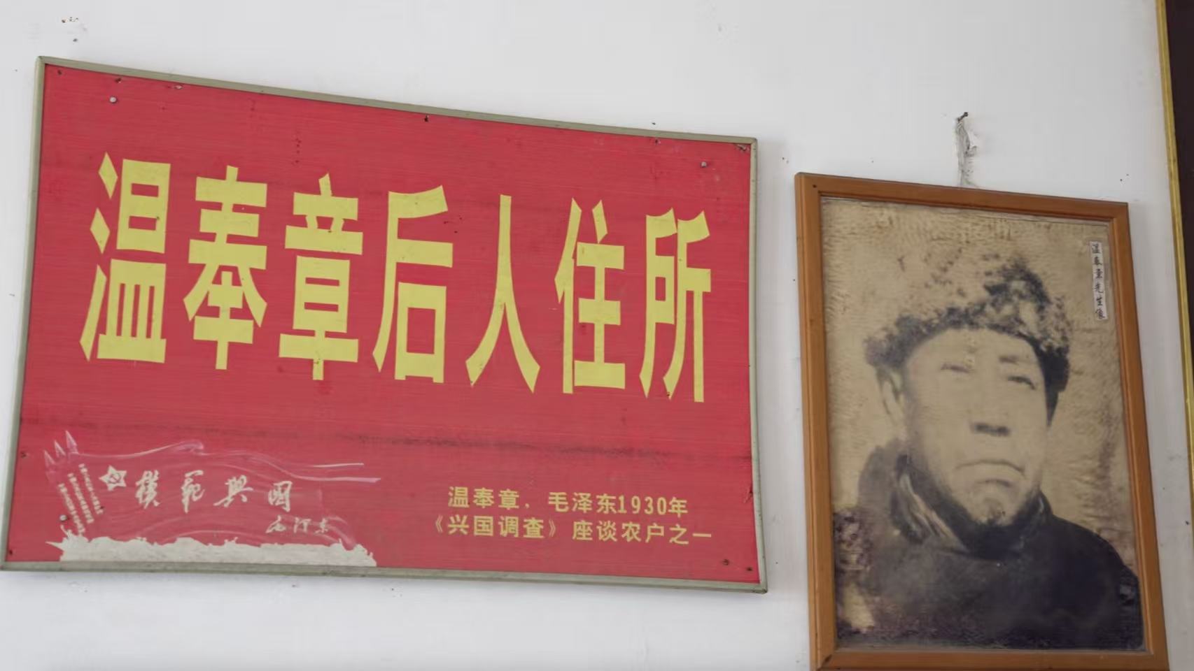 A portrait of Wen Fengzhang hangs beside a commemorative plaque at the home of his son, Wen Changxin, in Yongfeng Township, Xingguo County, Jiangxi Province, China, August 27, 2026. /CGTN