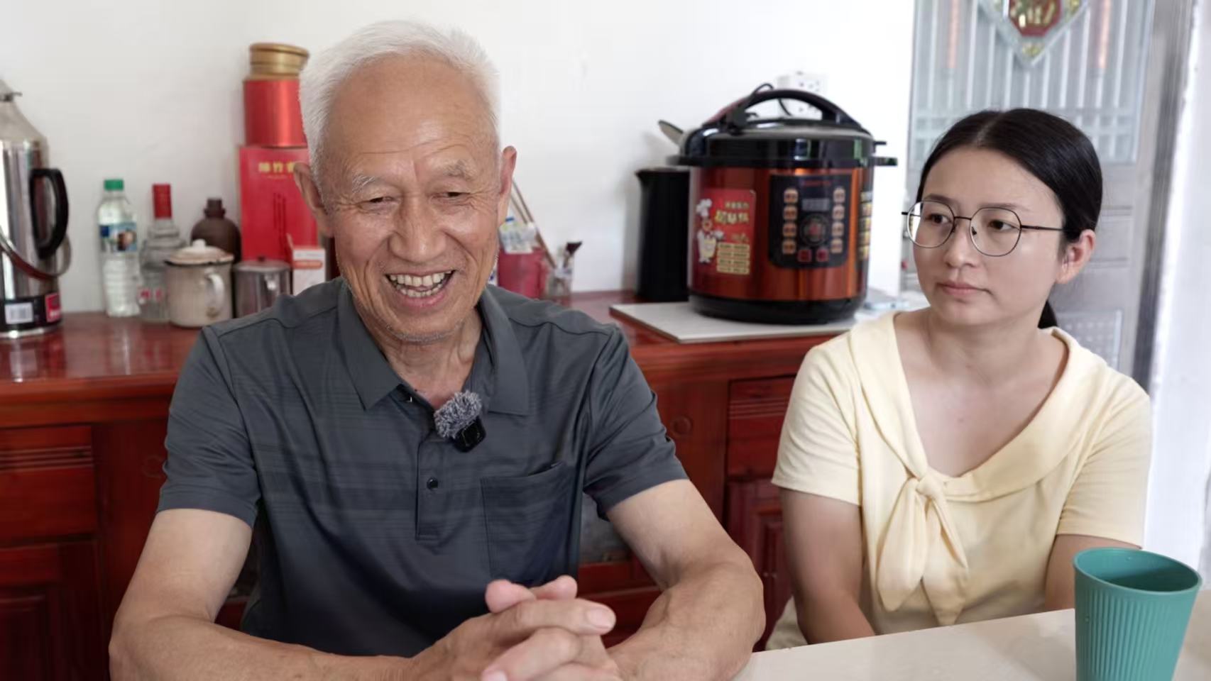 Wen Changxin, 80, sits with his granddaughter at his home in Yongfeng Township, Xingguo County, Jiangxi Province, China, August 27, 2026. /CGTN