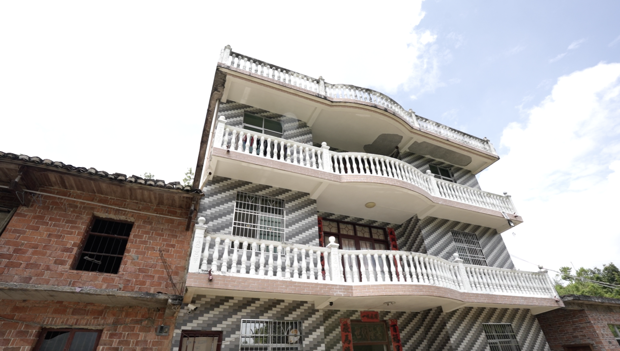 The home where Li Jiyuan and his family now live stands beside the family's older house in Yongfeng Township, Xingguo County, Jiangxi Province, China, August 27, 2026. /CGTN