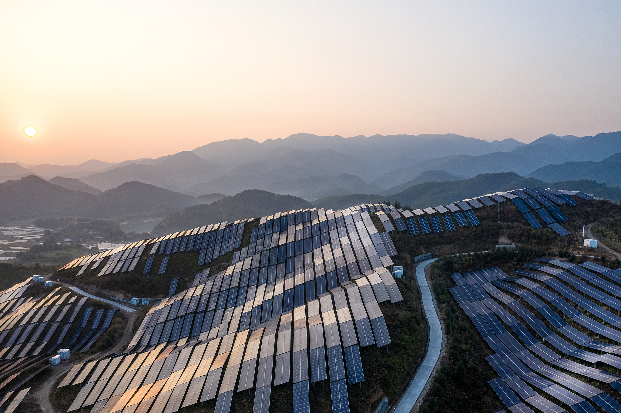 A file photo shows an aerial view of a solar power plant at sunset in a mountainous area. /CFP