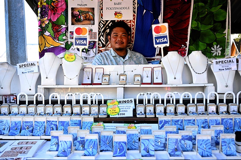 A stallholder displays his wares to tourists at a market on the main island of Rarotonga, in the Pacific Ocean state of the Cook Islands, June 14, 2025. /CFP