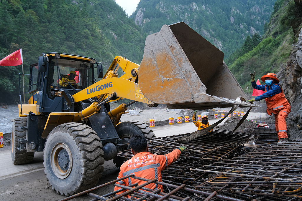 Rescue workers prepare and transport steel-reinforced cages on site to strengthen the roadbed, Gyirong, August 30, 2026. /VCG