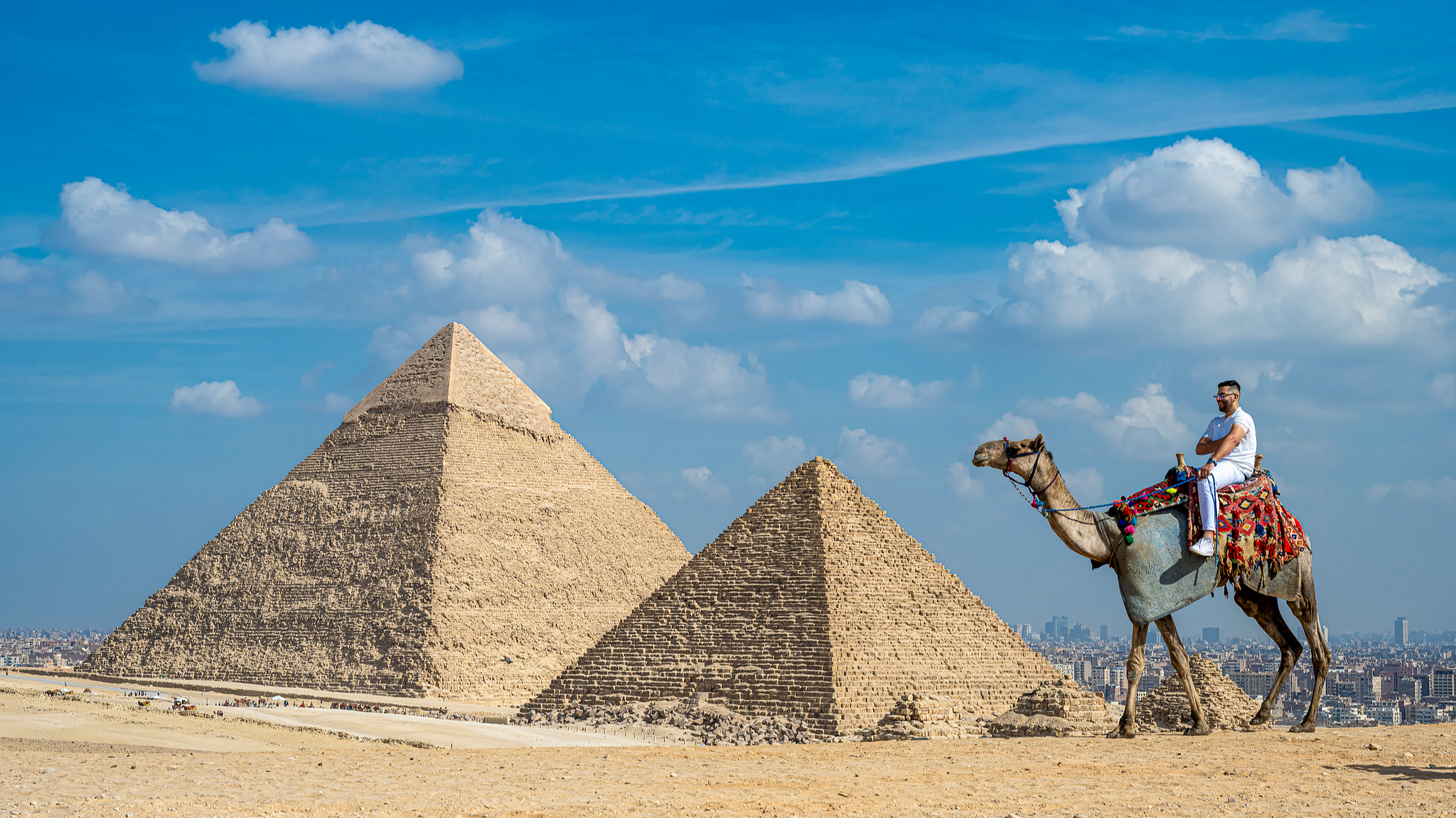 A tourist rides a camel near the pyramids in Giza, Egypt, November 11, 2024. /CFP