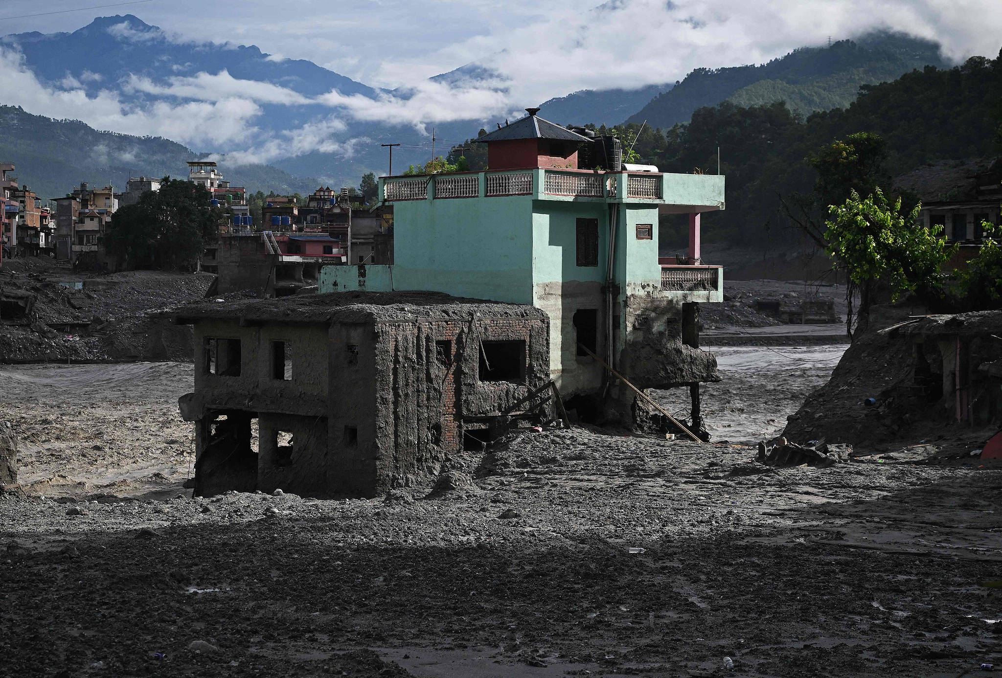A turquoise-green house stands tall amid sludge near Trishuli river in the aftermath of flash floods at Trishuli Center in Nepal's Nuwakot district on September 2, 2026. /VCG