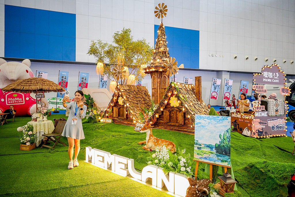 Visitors take selfies at the booth of Memeland, a local family amusement park in Tianjin, on September 3, 2026. /VCG