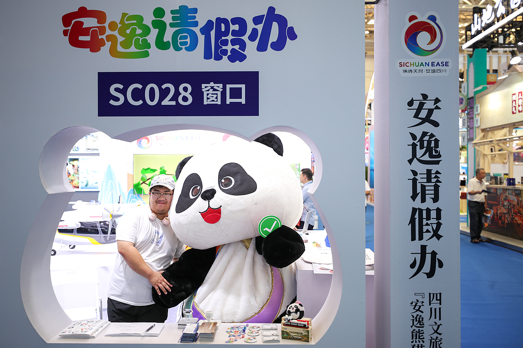 Visitors take photos with a panda mascot at the 2026 China Culture and Tourism Industries Expo on September 3, 2026, in Tianjin. /VCG