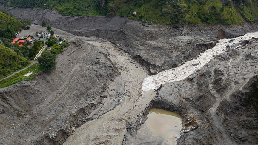 An aerial view shows a torrent of muddy water surging past houses and through the Trishuli River in the aftermath of flash floods near the Nepal-China border at Syabrubesi Village in Nepal's Rasuwa District, August 31, 2026. /AFP