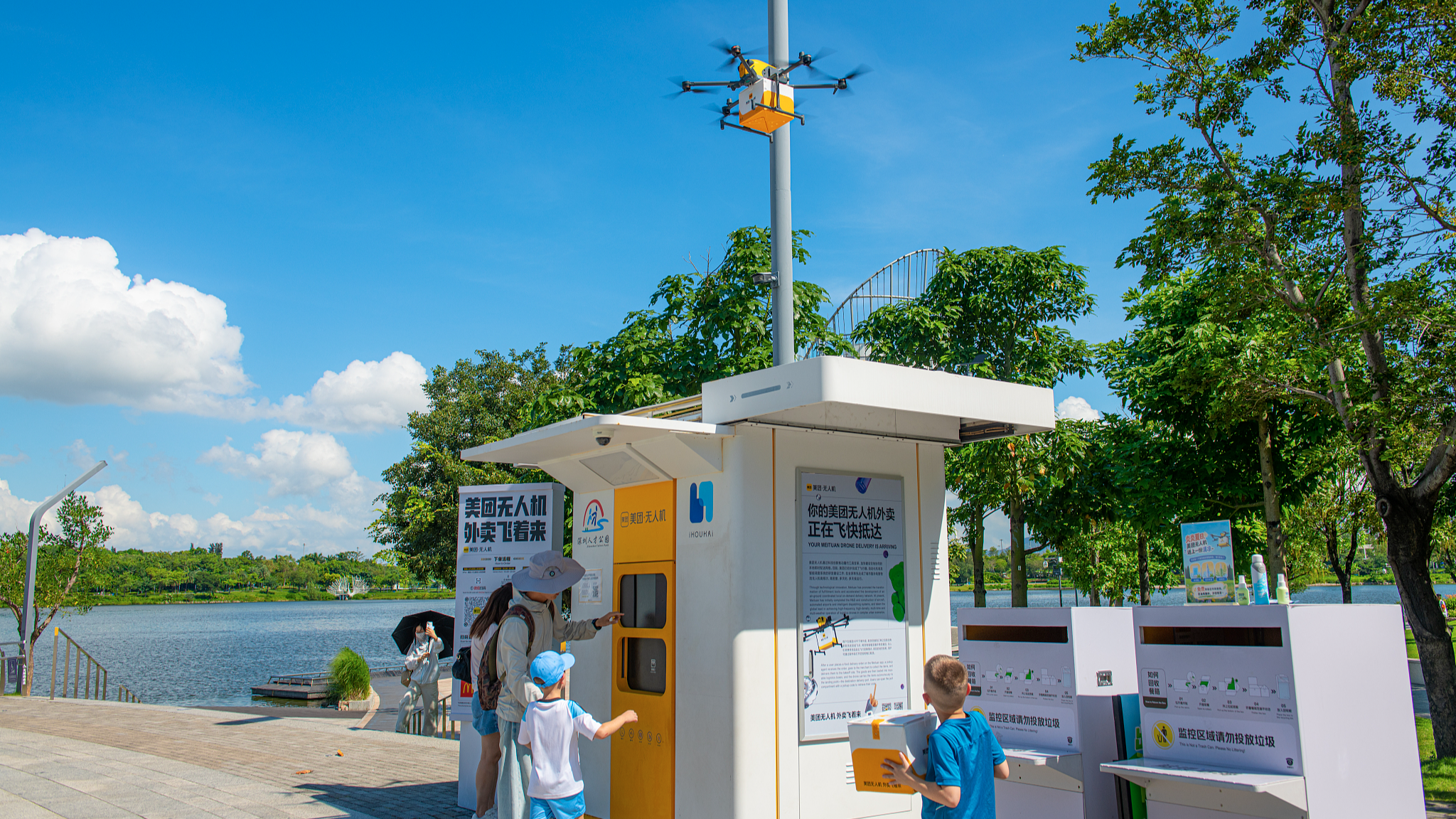 Foreign visitors try the drone food delivery service at a park in Shenzhen, south China's Guangdong Province, June 21, 2026. /VCG