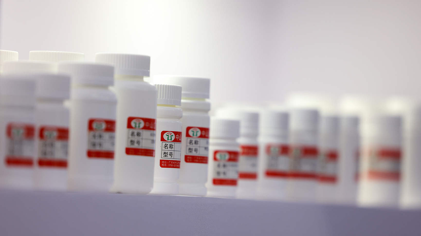 White medicine bottles displayed by a pharmaceutical company at an international exhibition for pharmaceutical ingredients, Shanghai, China, June 20, 2024. /VCG