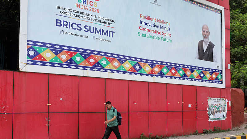An Indian man walks in front of a BRICS billboard placed ahead of the upcoming BRICS Heads of State Summit near the venue of the summit in New Delhi, India, September 8, 2026. /CFP