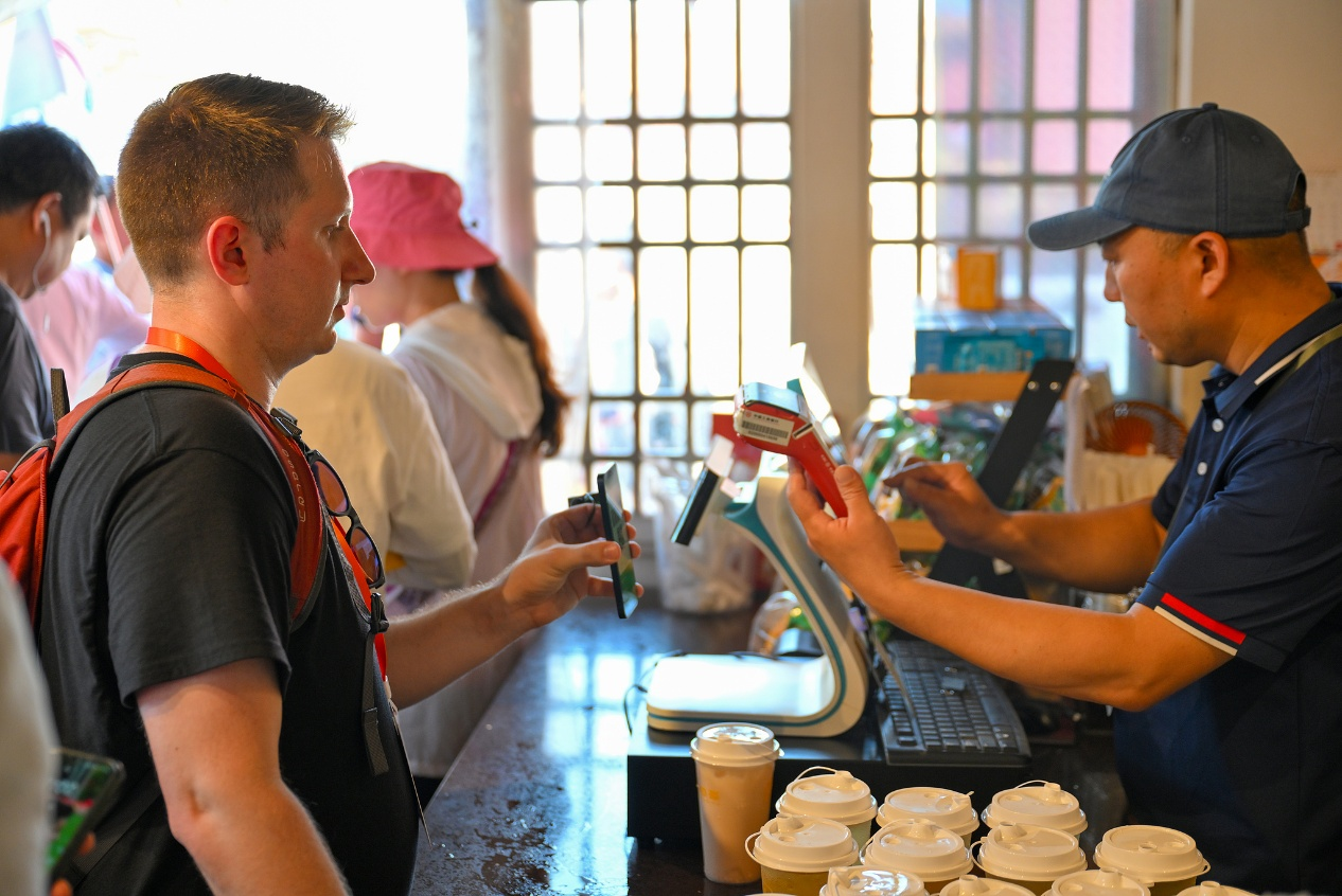 US youth delegates use mobile payment to buy drinks during a China-US youth exchange event in Beijing, China, on June 12, 2024. /VCG