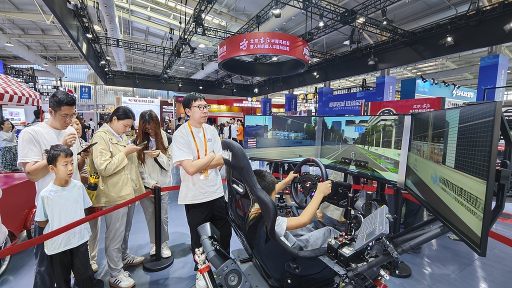 Visitors experience smart driving at an exhibition area in the Shougang Convention & Exhibition Center, Beijing, capital of China, September 13, 2026. /VCG