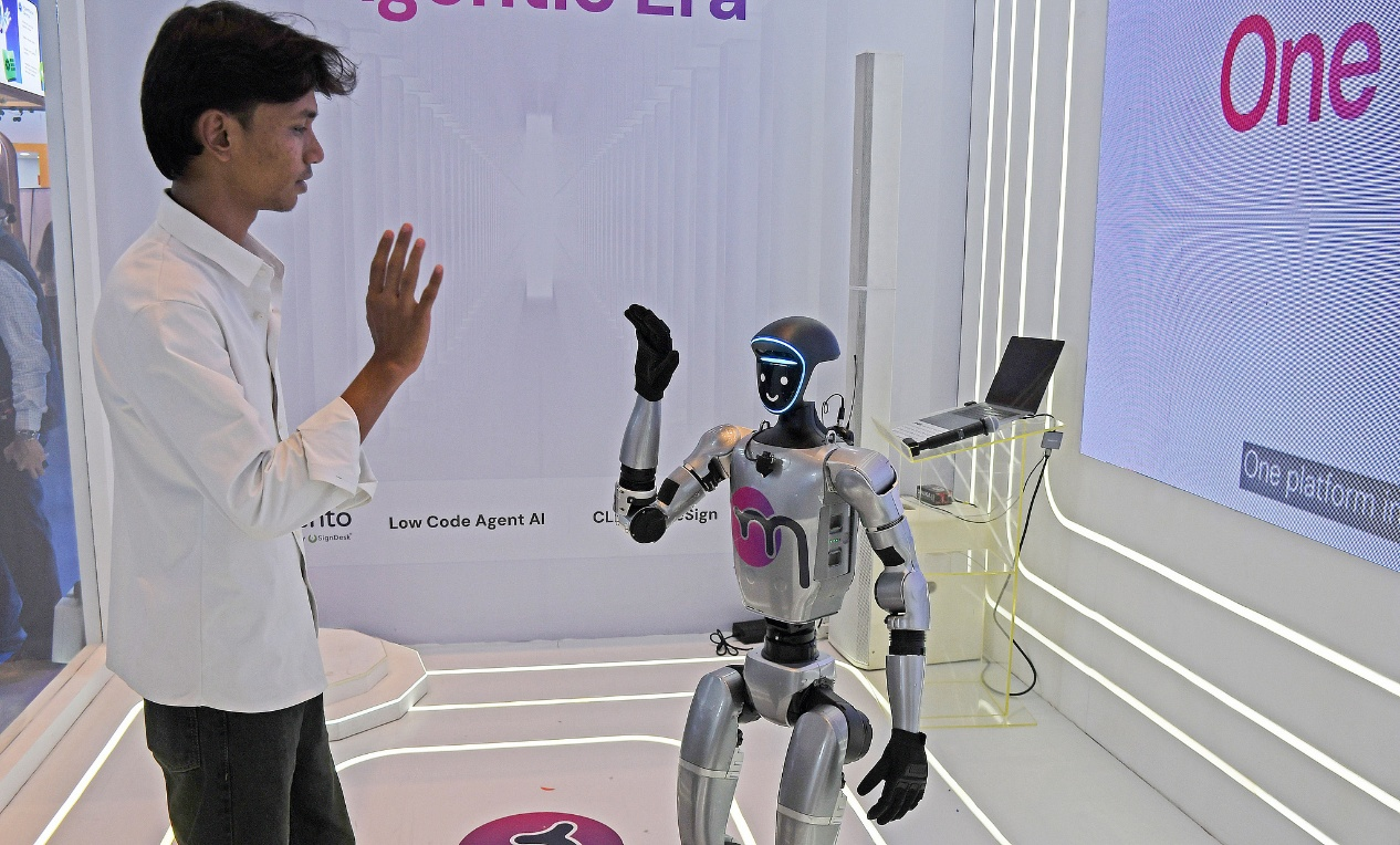 A humanoid robot seen waving to a man at the 7th edition of Global Fintech Fest (GFF) in Mumbai, India, September, 9, 2026. /VCG
