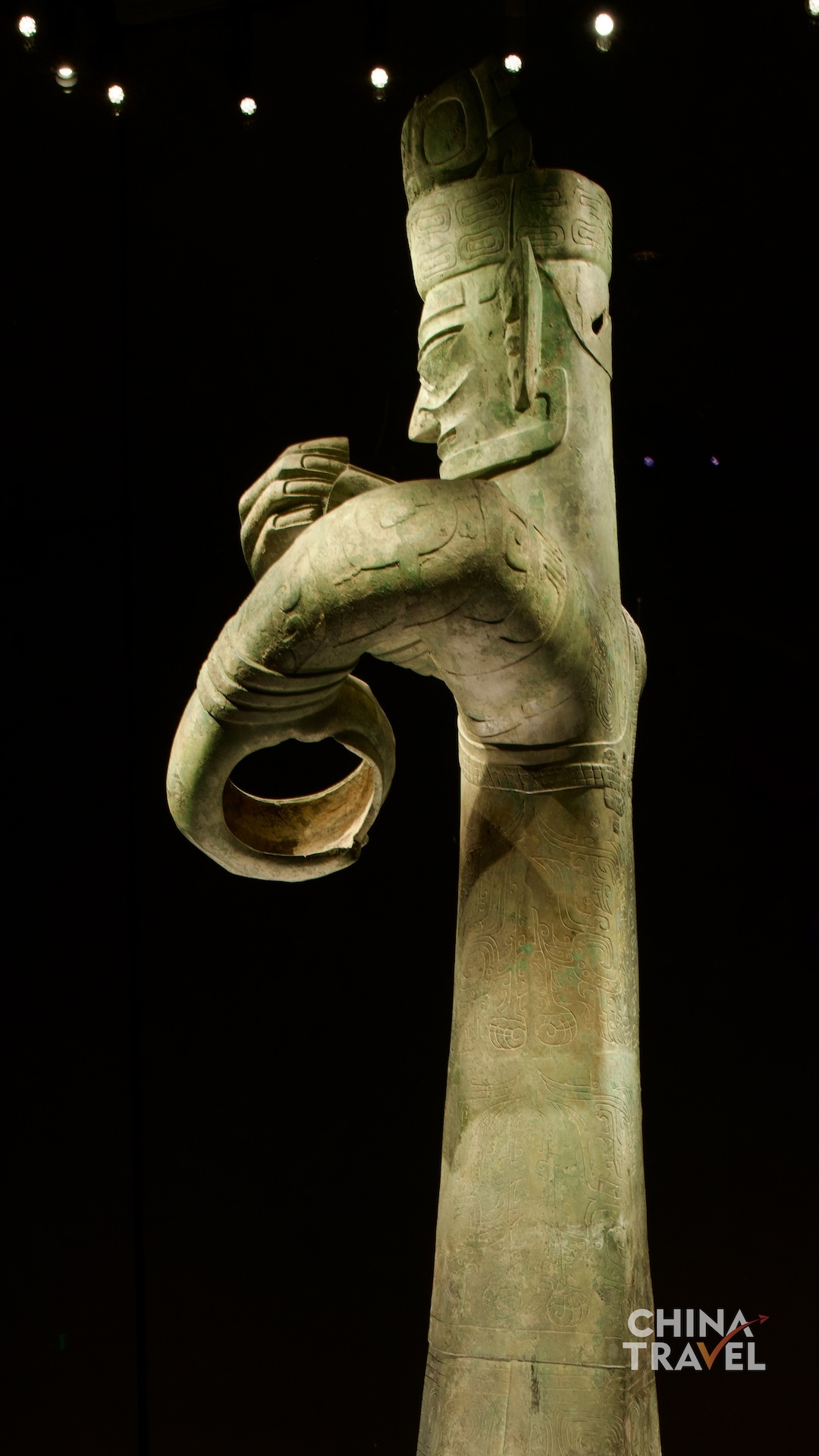 Close and side views bring together the high crown, stylized face, patterned garments and differently positioned circular grips – the focus of debate over what the figure may once have held. /CGTN