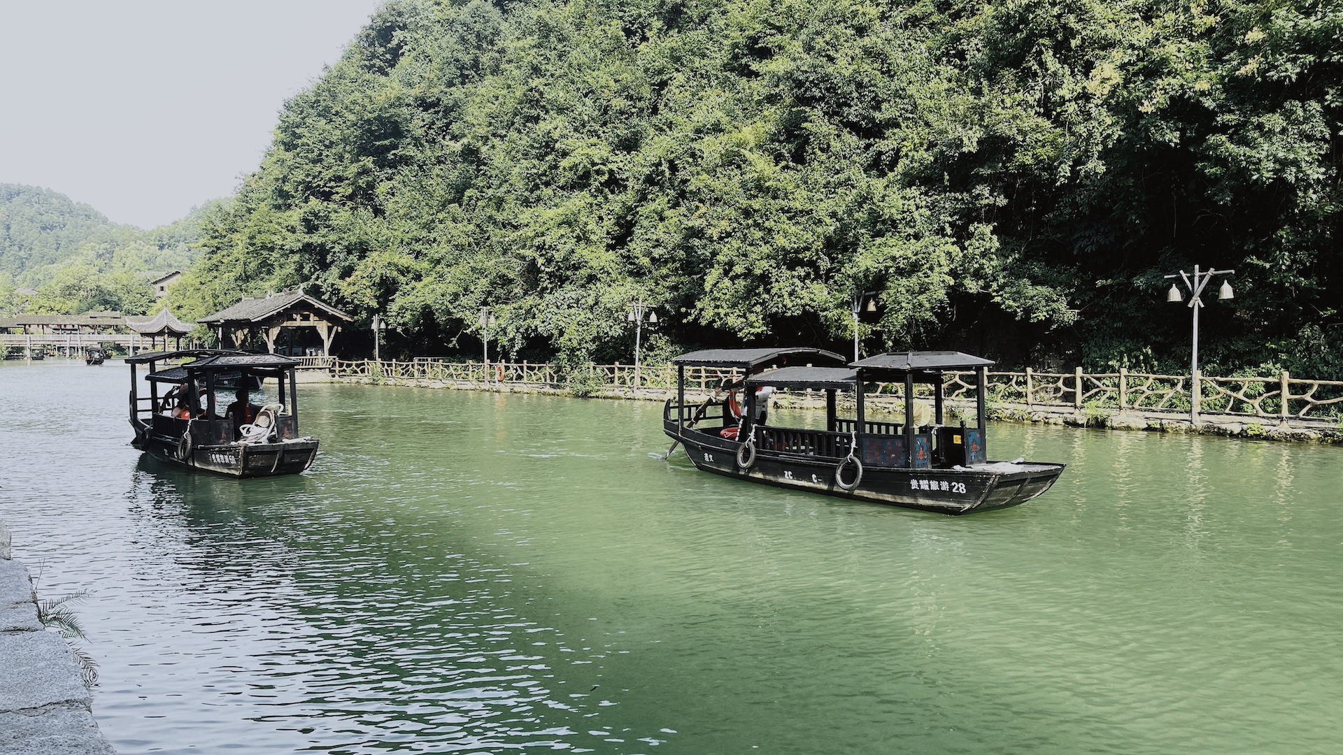 Wooden sculling boats travel along the Wujiang River in Guizhou, China. /CGTN