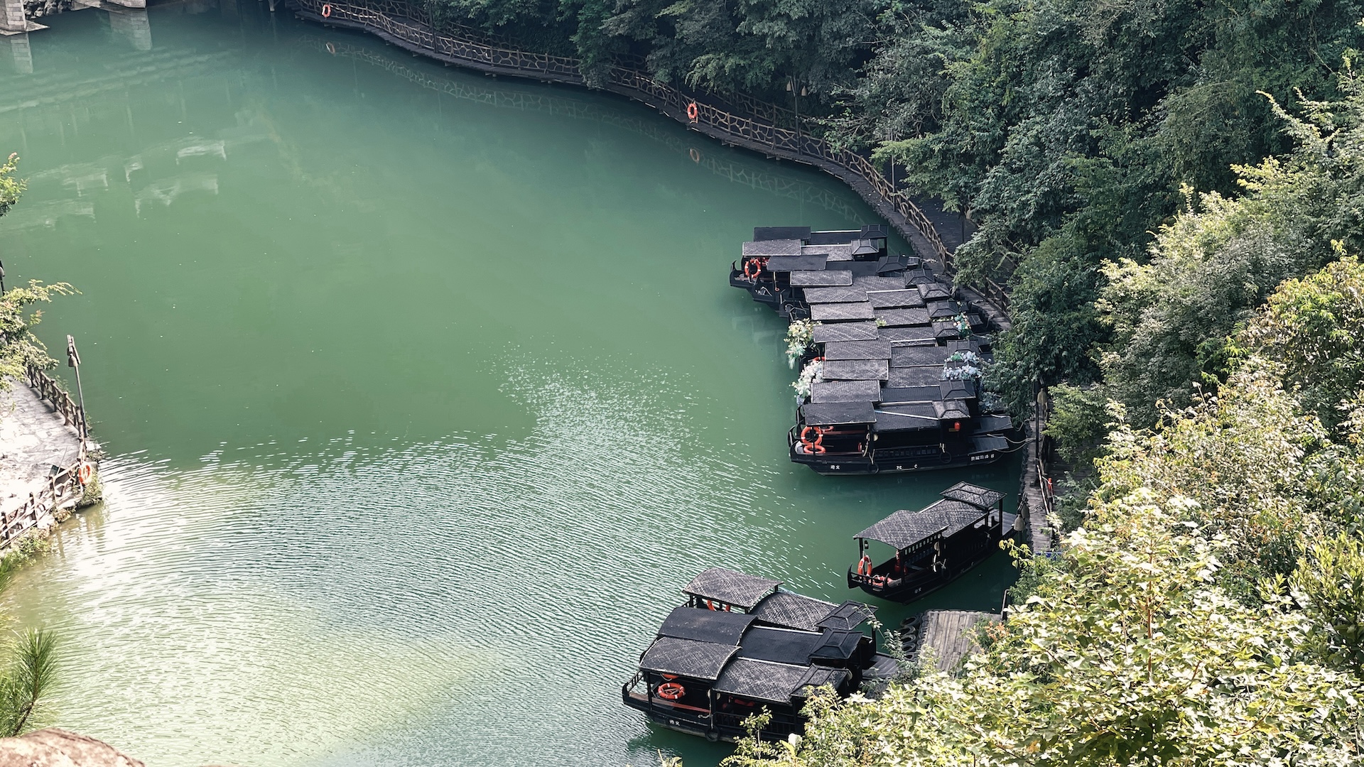 Several wooden sculling boats are moored along the Wujiang River in Guizhou Province, China. /CGTN