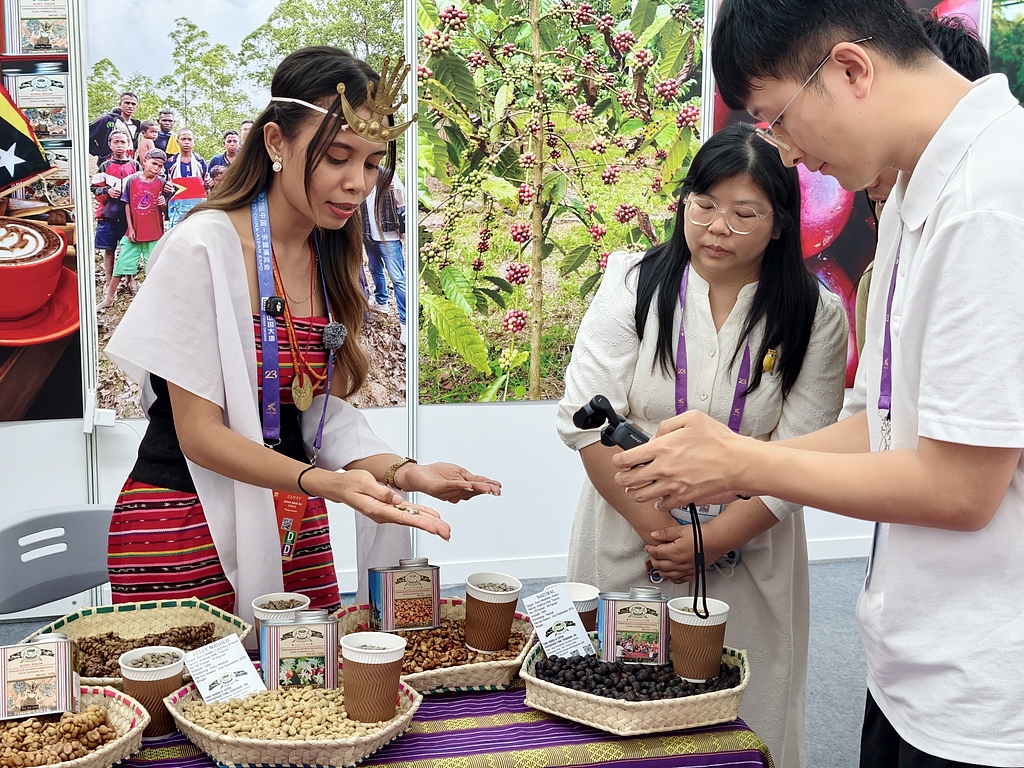 An exhibitor introduces Timor-Leste's local agricultural specialties to a visitor during the 23rd China-ASEAN Expo in Nanning, September 17, 2026. /VCG