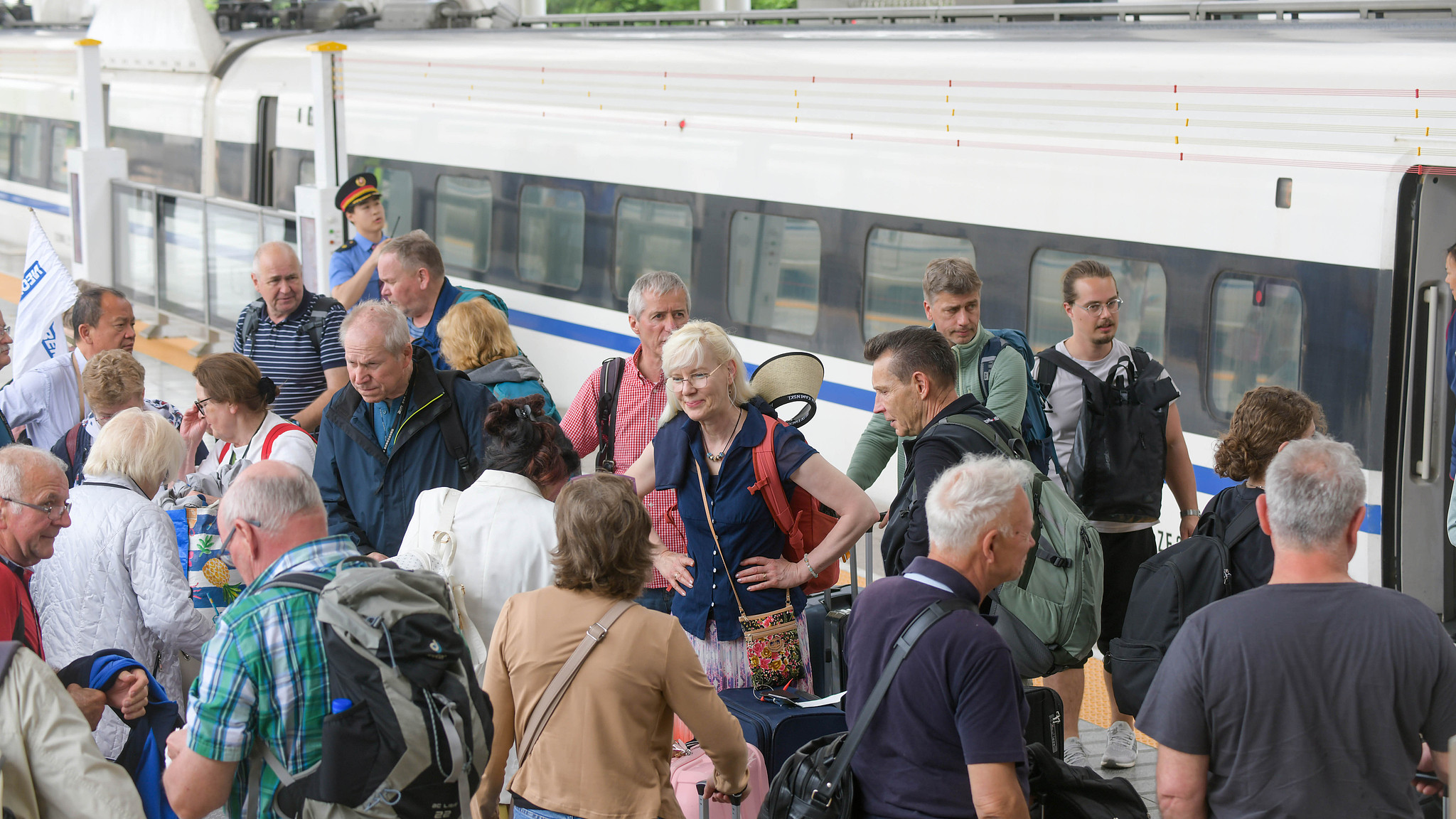 Foreign tourists wait to board a high-speed train at Luoyang Longmen Railway Station in Luoyang, central China's Henan Province, May 1, 2026. /VCG