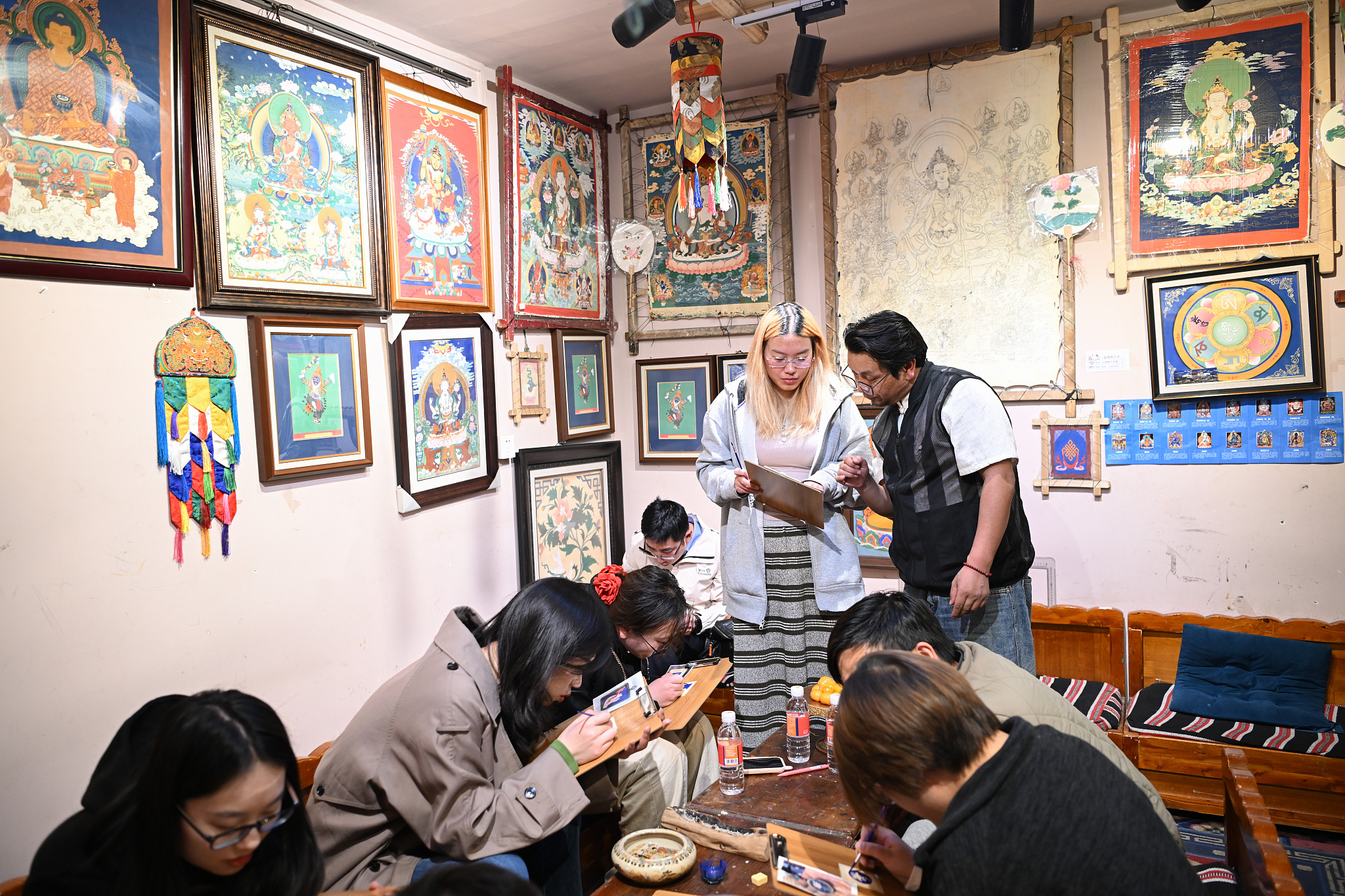 Night school students learn to paint thangkas at a cultural and creative experience center for thangka art in Lhasa, Xizang Autonomous Region, May 14, 2025. /CFP