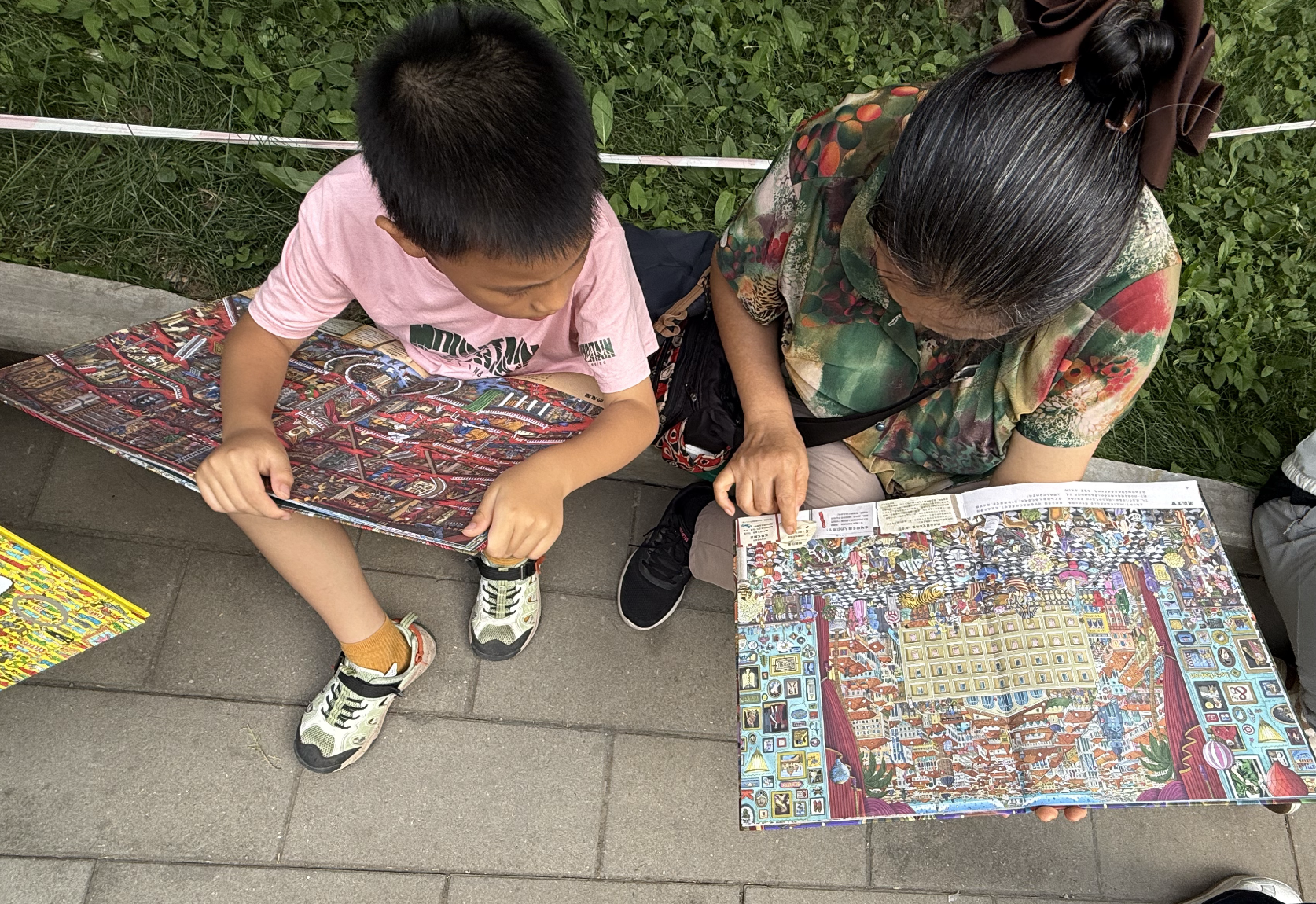 Visitors sitting on the pavement to read the newly-purchased books at the Ditan Book Fair 2026, September 19, 2026, Zaruhi Poghosyan /CGTN