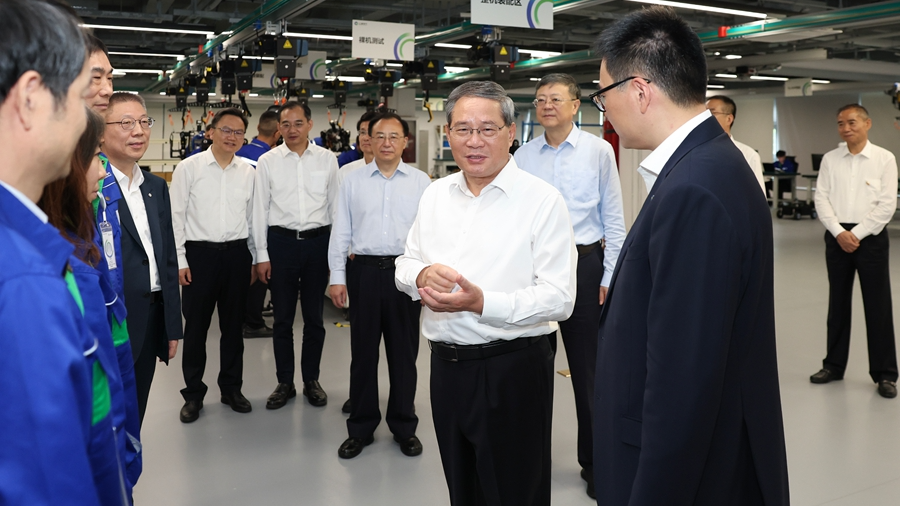 Chinese Premier Li Qiang talks to workers at a pilot test base for artificial intelligence (AI) applications on an inspection tour in Shanghai, China, September 22, 2026. /Xinhua