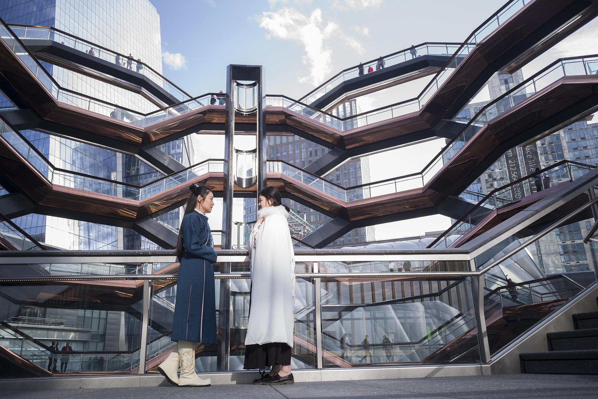 Two Chinese students pose for photos wearing traditional Chinese attire inside Vessel, a landmark in New York City, March 15, 2019. /CFP