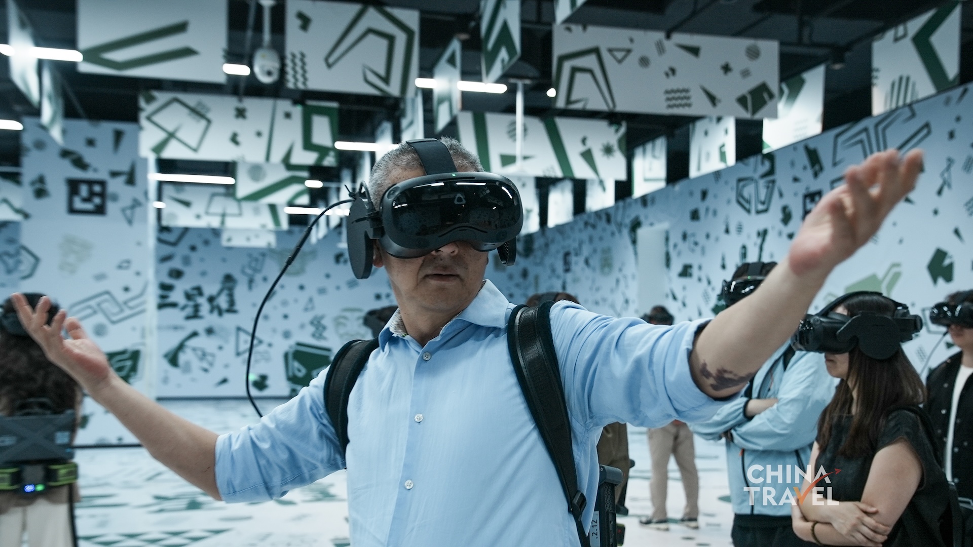 Visitors adjust headsets, enter the tracked room and use physical gestures to interact with the shared virtual environment at the new Sanxingdui Museum in Guanghan, Sichuan Province. /CGTN