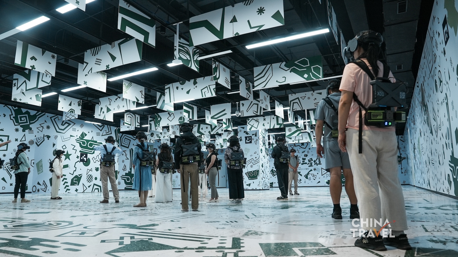 Wide views show multiple participants moving independently within one mapped play area supported by headsets and backpack computers at the new Sanxingdui Museum in Guanghan, Sichuan Province. /CGTN