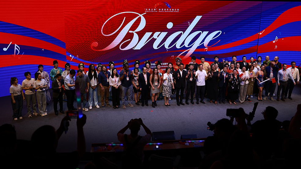 Guests and performers pose for a group photo following the theme concert of the 