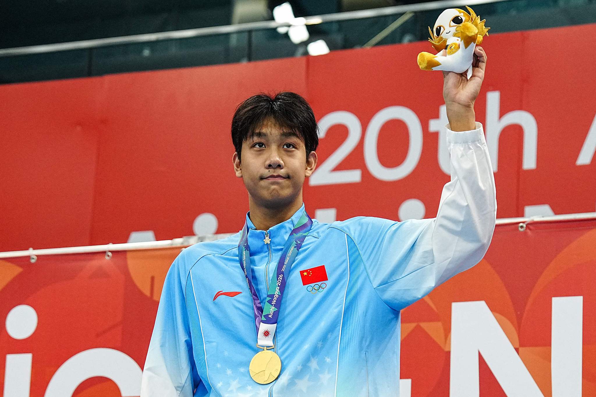 China's gold medalist Zhang Zhanshuo celebrates on the podium during the victory ceremony of the men's 1500m freestyle swimming event during the Asian Games at the Tokyo Aquatics Centre in Tokyo, Japan, September 22, 2026. /VCG