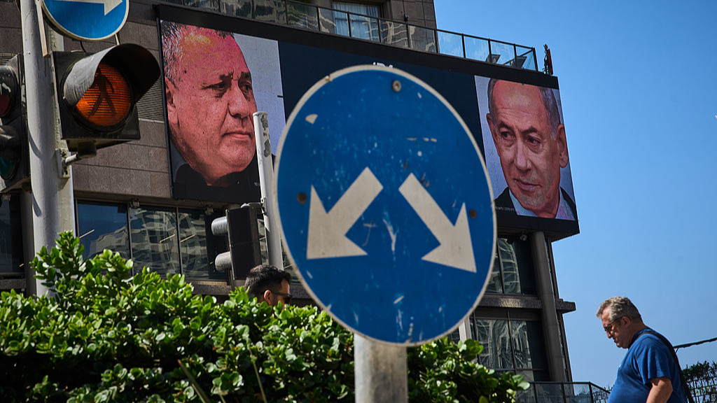 A man walks past a television channel advertisement featuring Israeli Prime Minister Benjamin Netanyahu (R) and his main rival, opposition candidate Gadi Eisenkot, ahead of Israel's general election, Ramat Gan, Israel, September 23, 2026. /VCG