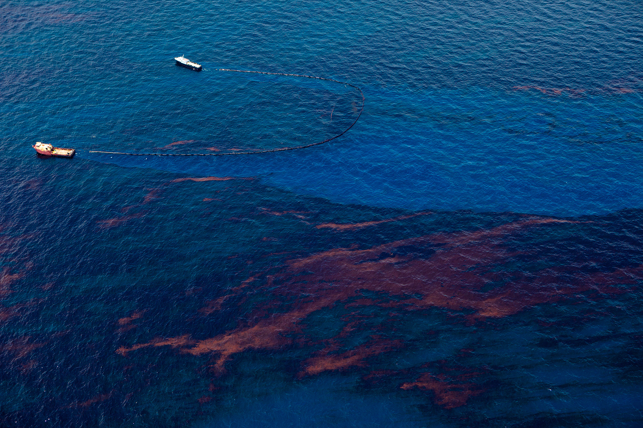 Two vessels clean up an oil spill in the bay. /VCG