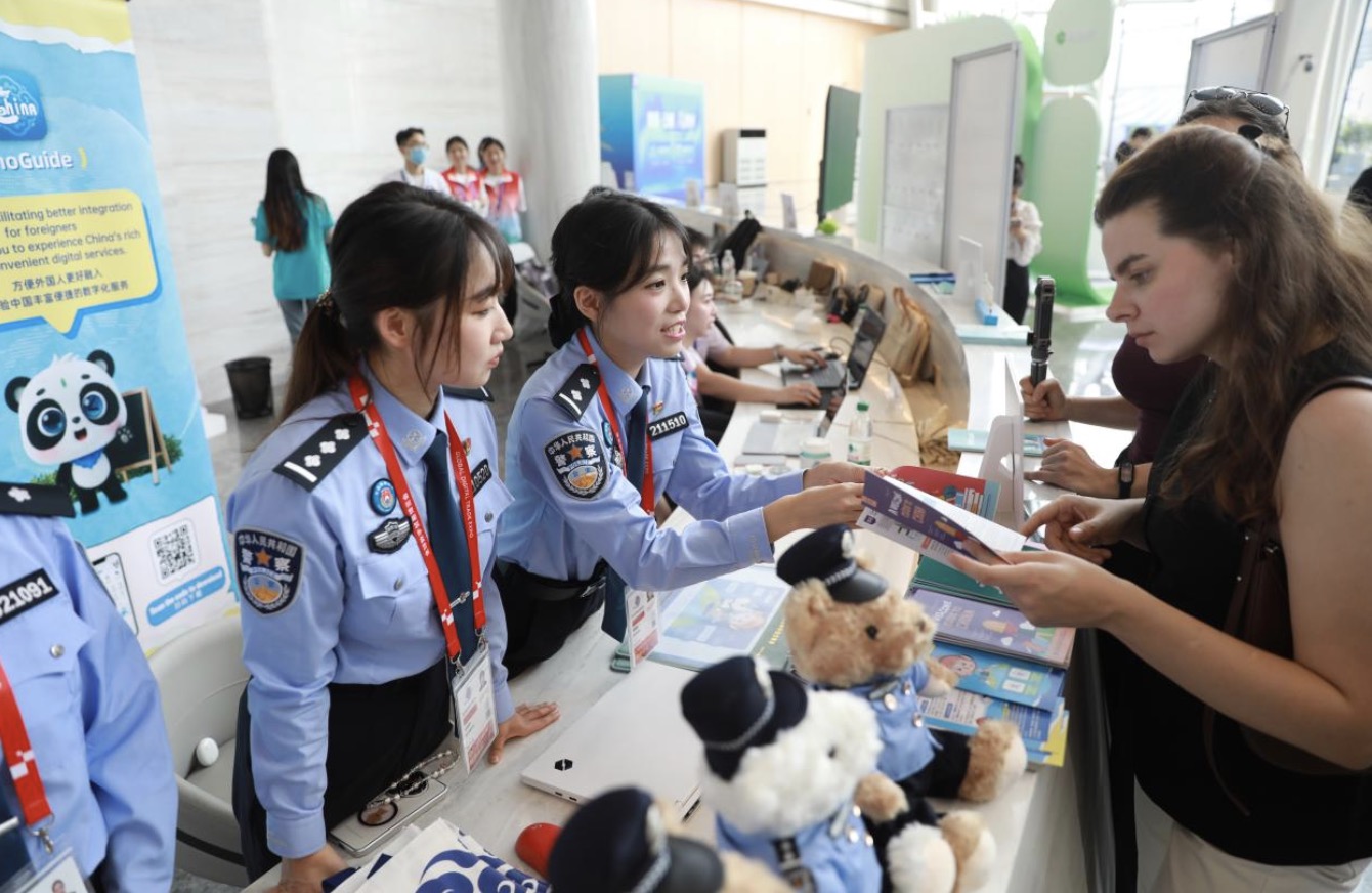 Police officers from the Hangzhou Exit-Entry Border Inspection Station explaining relevant policies to international business travelers at the Global Digital Trade Expo (GDTE), Hangzhou, Zhejiang Province, September 23, 2026. /CMG