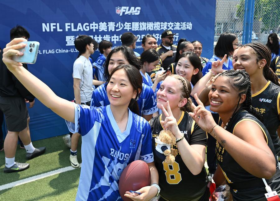 Students from Lincoln High School in Washington State and Beijing National Day School pose for a group photo after a flag football exchange, May 26, 2025. /Xinhua
